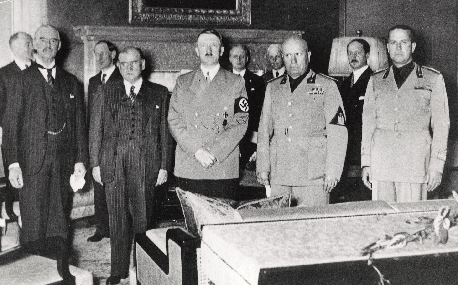 Several men in a room standing next to and behind each other and looking at the camera.