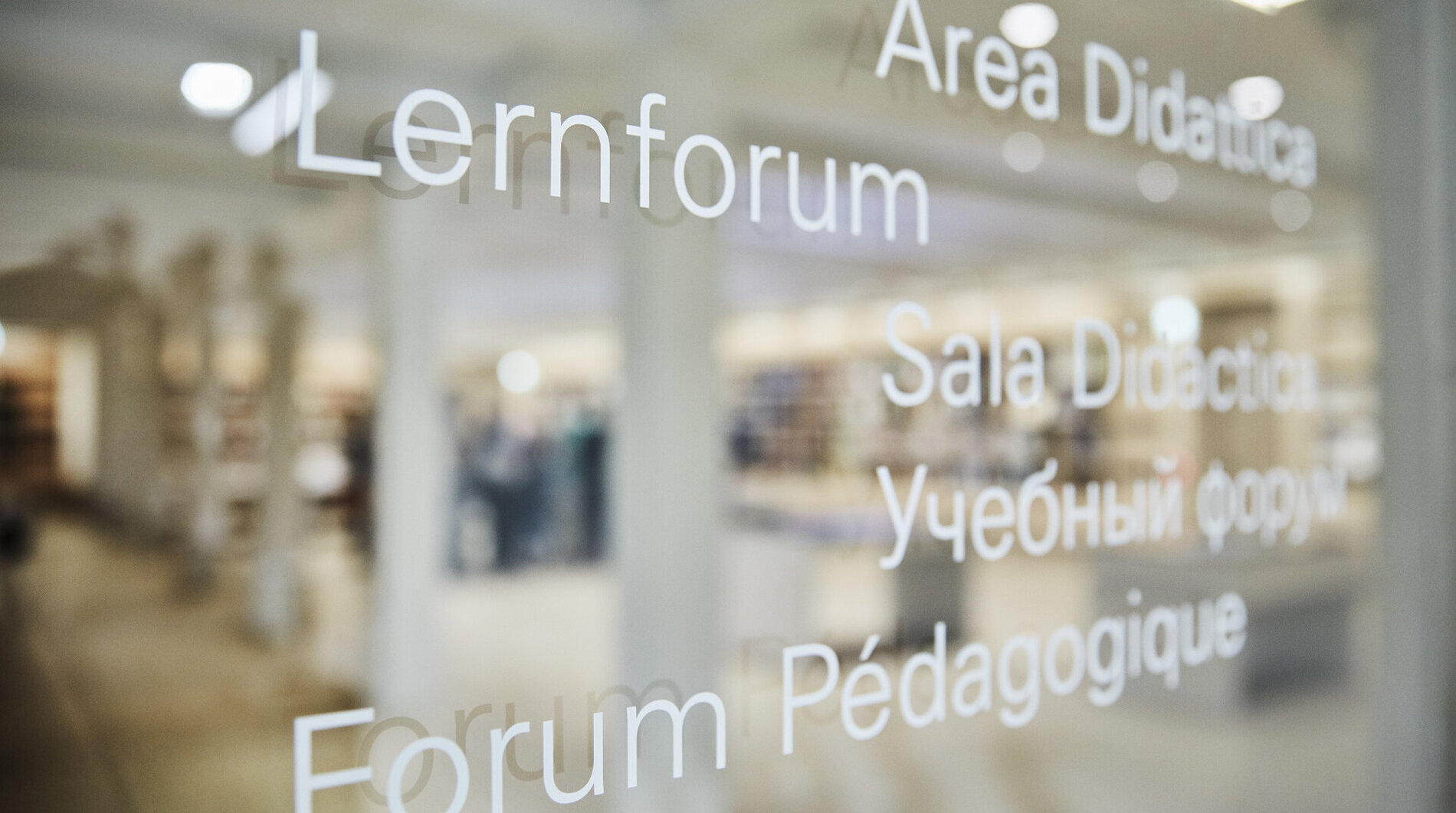 Auf der Eingangstür aus Glas steht das Wort ‚Lernforum‘ auf fünf verschiedenen Sprachen.