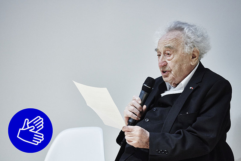Max Mannheimer spricht in ein Mikro und hält einen Zettel in der Hand