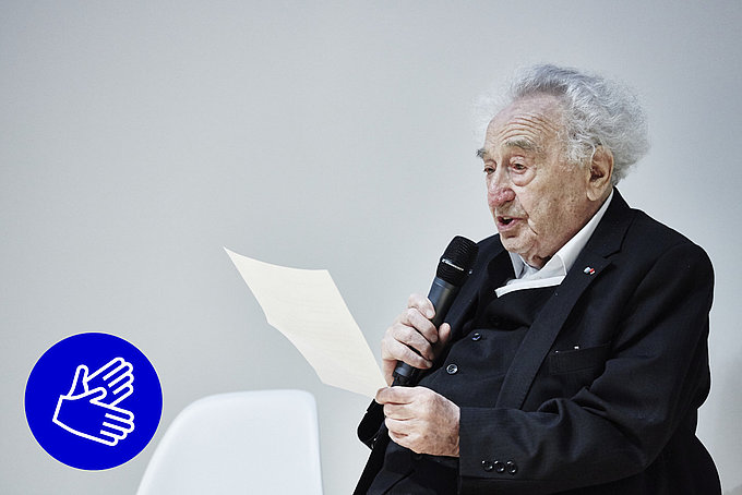 Max Mannheimer spricht in ein Mikro und hält einen Zettel in der Hand