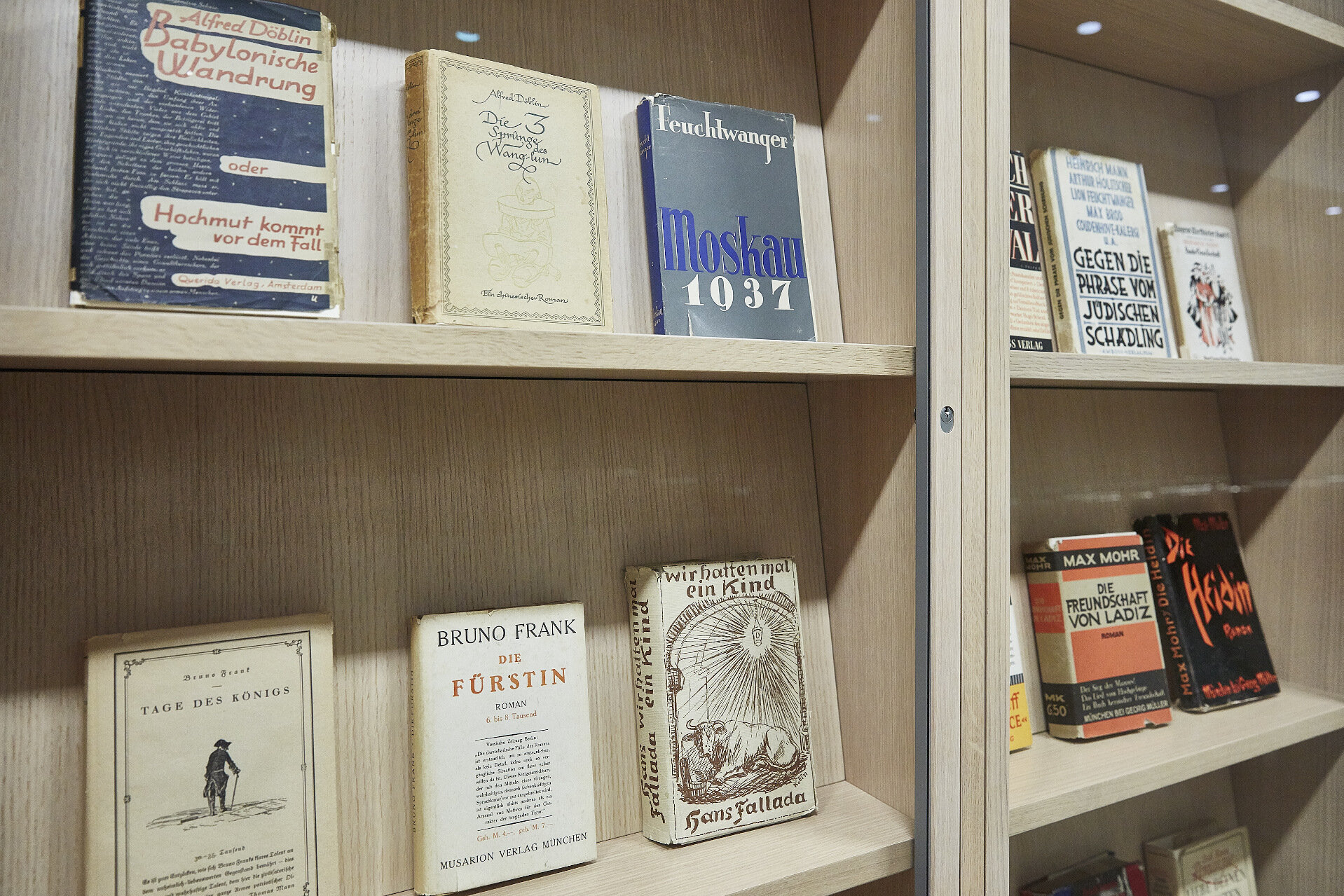 The covers of books by Lion Feuchtwanger, Alfred Döblin, Bruno Frank, Hans Fallada, Max Mohr, and others are shown in the display cases.